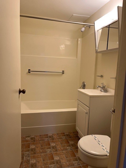 A white toilet with a blue stripe is in a bathroom with a walk-in shower.